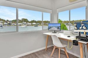 oficina con escritorio, ordenador y ventanas en Waterfront Bliss at Balmoral Lake Macquarie, en Balmoral