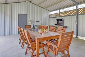 mesa de comedor y sillas en un edificio en Waterfront Bliss at Balmoral Lake Macquarie, en Balmoral