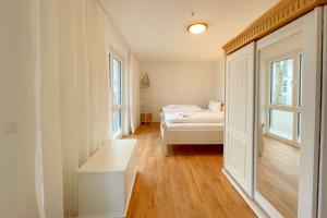 a small room with a bed and a window at Bernsteinquartier Ferienwohnung Blaues Fenster in Kölpinsee