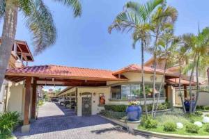 a house with palm trees in front of it at No mar, condomínio pé na areia in Florianópolis