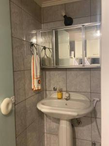 a bathroom with a white sink and a mirror at No mar, condomínio pé na areia in Florianópolis +56 photos