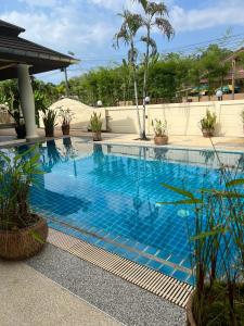 a swimming pool with blue water in a resort at Grand Villa Khaolak in Khao Lak