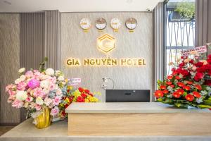 a reception desk with flowers in front of a sign at Gia Nguyễn Hotel Dalat in Da Lat