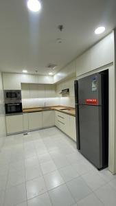 Il dispose d'une cuisine avec un réfrigérateur noir et du carrelage blanc. dans l'établissement شقق انار السكني, à Khobar