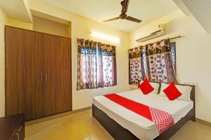 um quarto com uma cama com almofadas vermelhas em OYO Shree Balaji Residency em Chennai
