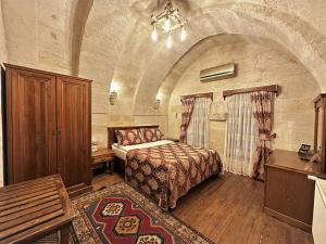 a bedroom with a bed in a large room at Stone House Cave Hotel in Göreme