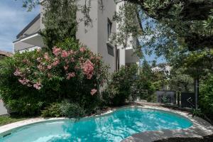 - une piscine en face d'un bâtiment fleuri dans l'établissement MATTEOTTi Apartments, à Desenzano del Garda