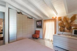 un salon avec une chaise rouge et une télévision dans l'établissement MATTEOTTi Apartments, à Desenzano del Garda