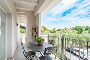 een patio met een tafel en stoelen op een balkon bij MATTEOTTi Apartments in Desenzano del Garda