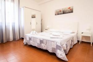 Casa Vacanze Tosca 3 في بيزا: غرفة نوم بيضاء مع سرير عليه مناشف