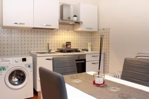 a kitchen with a washing machine and a table with a washer at Casa Vacanze Tosca 3 in Pisa