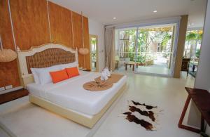 1 dormitorio con 1 cama con cabecero de madera en Summer Luxury Beach Resort & Spa, en Baan Tai