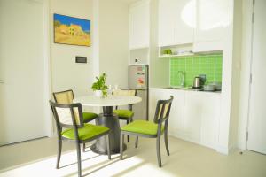 a kitchen with a table and chairs in a kitchen at S Gen Hillside Condotel Phu Quoc in Phu Quoc