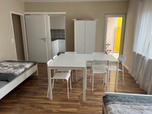 Cette chambre comprend une table et des chaises blanches ainsi qu'un lit. dans l'établissement Savanna Ferienwohnung, à Rodenbach
