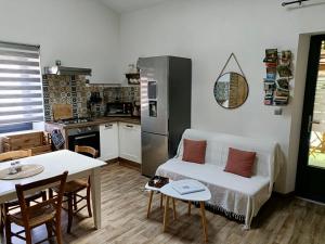 a living room with a white couch and a kitchen at L'Oustal in Montech