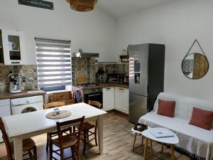 eine Küche und ein Wohnzimmer mit einem Sofa und einem Tisch in der Unterkunft L'Oustal in Montech