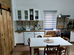 uma cozinha com uma mesa branca, uma mesa e cadeiras em L'Oustal em Montech