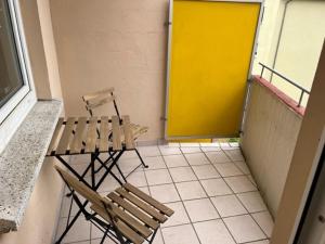 une chambre avec un banc et une porte jaune dans l'établissement Savanna Ferienwohnung, à Rodenbach