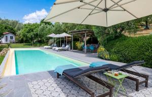 a pool with an umbrella and chairs and a table with at Casa Tabarro in Camaiore