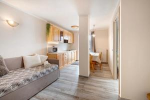 un salon avec un canapé et une cuisine dans l'établissement Appartamento Zefiro Livigno, à Livigno