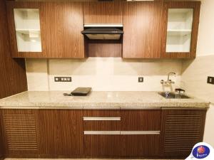a kitchen with a sink and wooden cabinets at PLUTO HOMES Dehradun in Dehradun