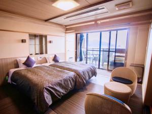 um quarto de hotel com uma cama e uma varanda em LiVEMAX RESORT Kyotango Sea Front em Kyotango