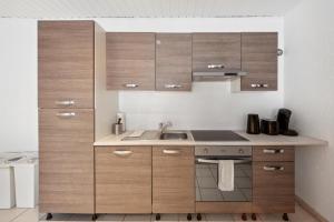 a kitchen with wooden cabinets and a sink at DA01 Monteurswohnung in Dieburg! in Dieburg