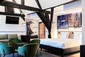 ein Hotelzimmer mit einem Bett und einer Couch in der Unterkunft Ghent Urbanist Hotel by Harmony in Gent