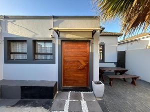 a house with a wooden door and a picnic table at 57onWYNNE in Cape Town