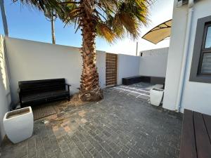 a palm tree and a bench next to a wall at 57onWYNNE in Cape Town