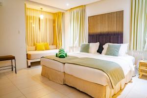 2 łóżka w pokoju hotelowym z żółtymi zasłonami w obiekcie Misibis Bay w mieście Cagraray