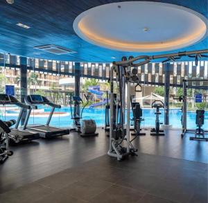 a gym with cardio equipment and a swimming pool at Cozy Private Studio with Luxurious Pool & Gym by SYM B622 in Phnom Penh