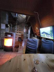een houten tafel met een wijnglas op een tafel met een open haard bij PV Giese Ferienhaus Damp in Damp