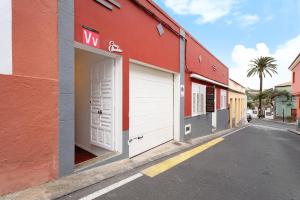 een rood gebouw met twee witte garagedeuren in een straat bij Casa Ubalda in Santa Cruz de Tenerife