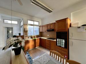 a kitchen with wooden cabinets and a white refrigerator at Retro Hostel in Limassol
