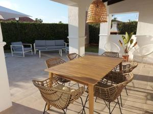 un tavolo e sedie in legno su un patio di Villa Juanes. Encanto, privacidad y relax. a Cala'n Bosch