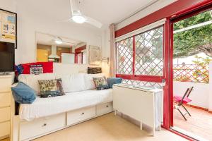 Una sala de estar con un sofá blanco y una ventana. en Casita playa, en Málaga 12 fotos más