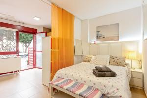 a bedroom with a bed and a large window at Casita playa in Málaga