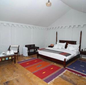 a bedroom with a large bed and a table at Desert Stay Camp in Sām