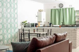 un soggiorno con divano e una cucina di Laha Apartment 3 a Maun