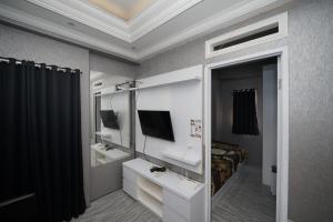 ein Schlafzimmer mit einem Spiegel, einem Bett und einem TV in der Unterkunft Perfect Stay Apartement The Suites Metro Bandung By Sultan Property in Bandung