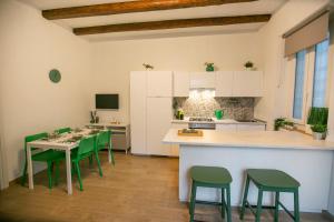 a kitchen with green chairs and a table and a counter at NonSoloValle in Chiaravalle
