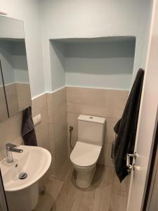 een badkamer met een wit toilet en een wastafel bij Filipa Apartment in Limenas
