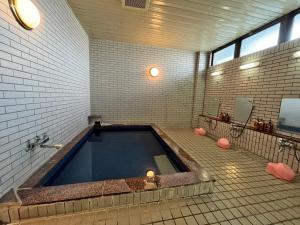een grote badkamer met een groot bad in de badkamer bij セミナープラザ　ロイヤルフジ in Azagawa