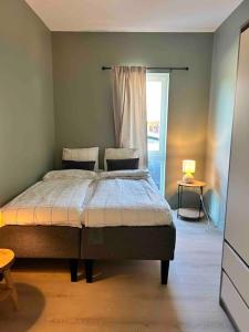 1 dormitorio con 1 cama con ventana y 1 cama sidx sidx sidx sidx en Helt ny leilighet i rolig område, en Sandefjord