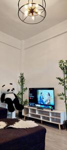 a living room with a flat screen tv and a panda bear at Logan's Transient Home - U2 Apartment with Balcony in Baguio