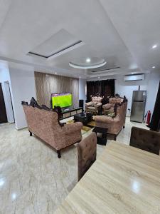 Serene Oasis في Ikorodu: غرفة معيشة مع كنب وتلفزيون بشاشة مسطحة