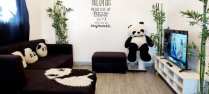 a living room with a panda bear on the wall at Logan's Transient Home - U2 Apartment with Balcony in Baguio