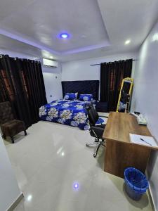 a bedroom with a bed and a desk and chairs at Serene Oasis in Ikorodu