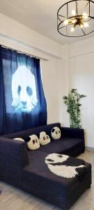 a black couch with pillows with a panda face on it at Logan's Transient Home - U2 Apartment with Balcony in Baguio